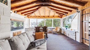 A covered patio area with a wooden ceiling, a cushioned sofa, a rocking chair, and a view of the outdoors. - Villa Frane by Interhome (Maslenica)