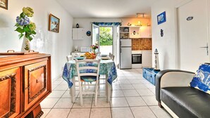 A compact kitchen with a dining area, a sofa, and a wooden cabinet. - Maisonneuve by Interhome (Ile d'Oléron)
