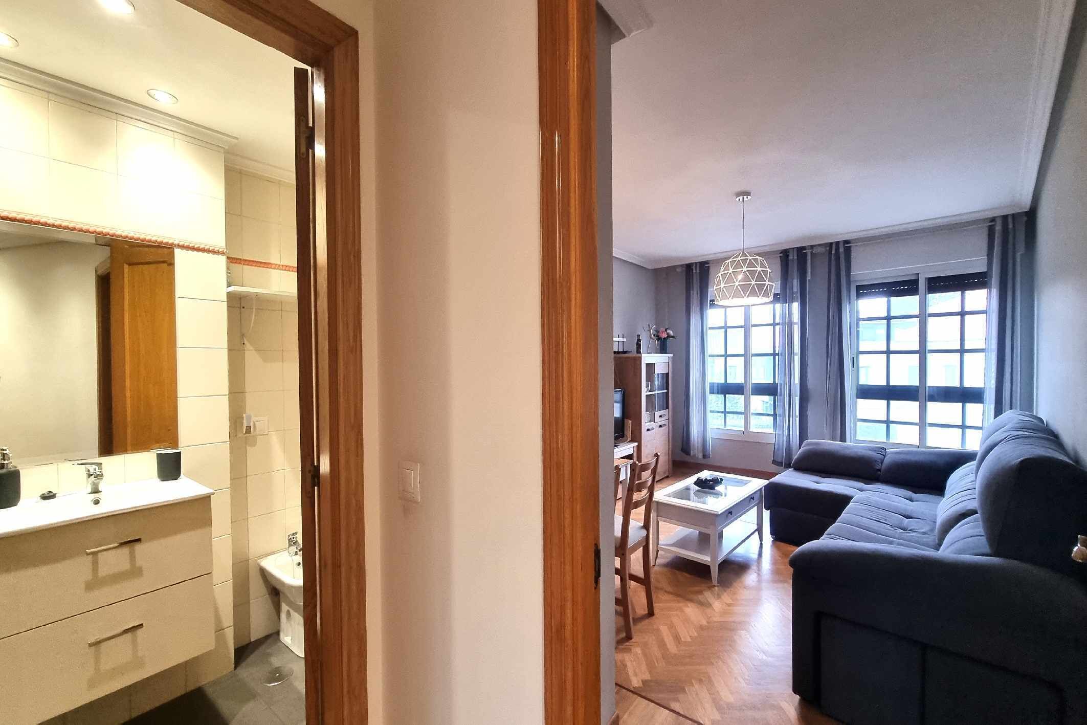 Un salon moderne avec un canapé foncé, une table basse et un coin repas.