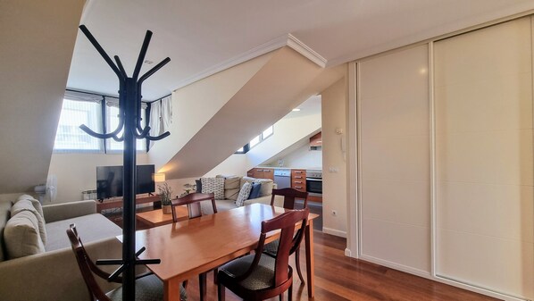 A modern loft apartment with a dining area, kitchen, and living space.