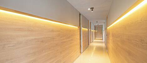 A modern hallway with wooden paneling and recessed lighting.