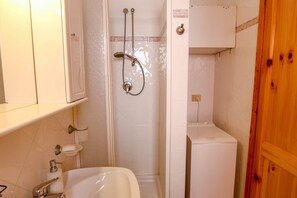 A bathroom with a shower, sink, and toilet.