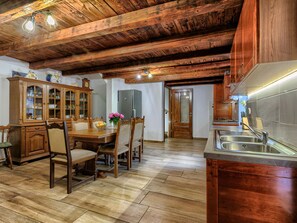 Enjoy meals at the dining table surrounded by comfortable chairs in this inviting kitchen.