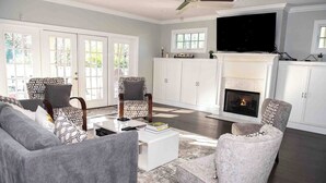 A living room with a fireplace, two armchairs, a sofa, and a coffee table. - Modern comfort within walking distance from UKY, Kroger Field, & Chevy Chase. (Lexington)