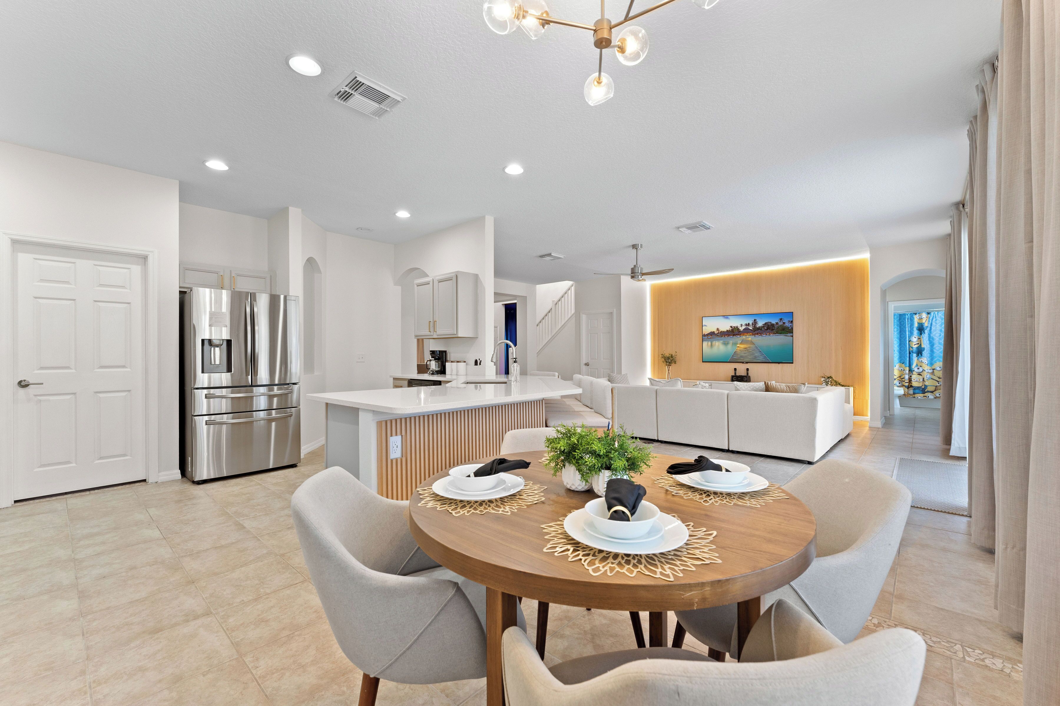 A modern kitchen with a built-in island, stainless steel appliances, and a dining area with a wooden table and chairs.