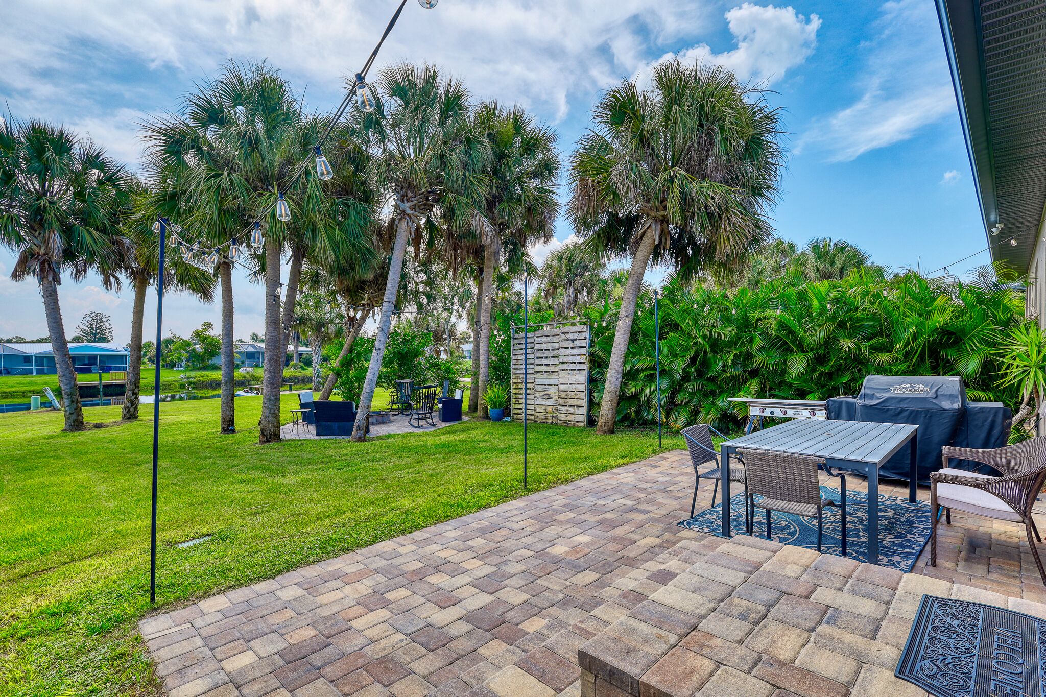 A patio area with a brick floor, outdoor furniture, and a grill.