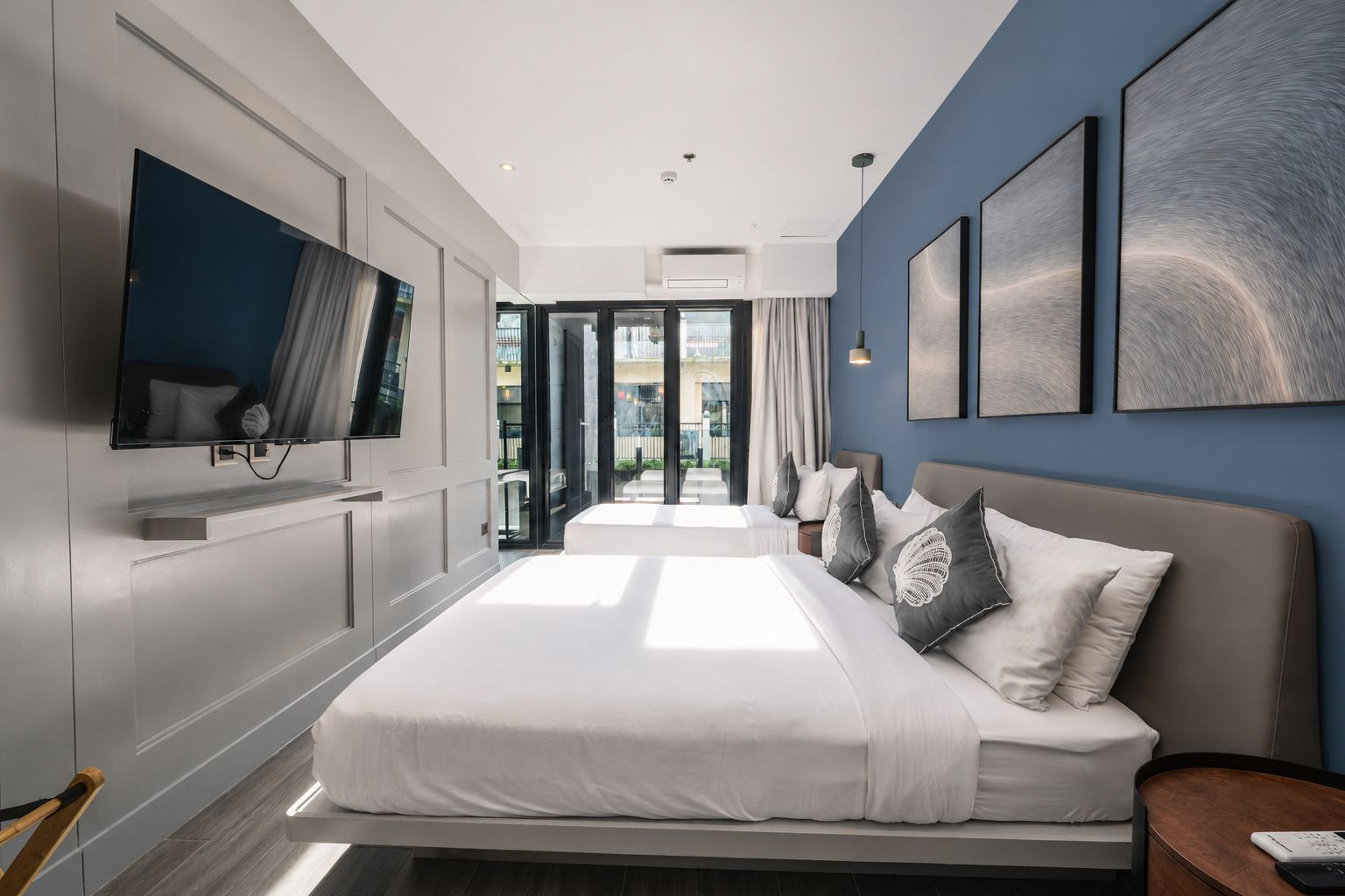 Habitación de hotel moderna con una cama grande, un televisor de pantalla plana y vistas al exterior.