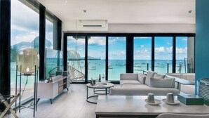 Un salón moderno con un gran ventanal que da a un puerto deportivo y al océano.