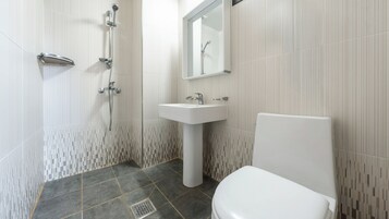 Un baño con ducha, lavabo e inodoro.