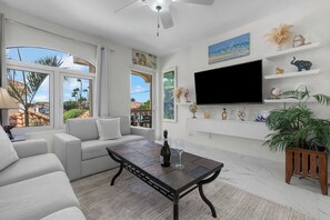 A modern living room with a sofa, a coffee table, and a flat-screen TV.