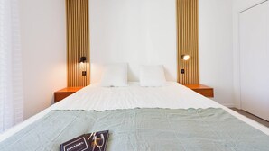 Ein Hotelzimmer mit einem großen Bett, zwei Nachttischen und einer Wandleuchte.