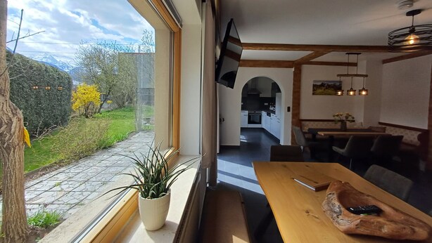 Una cocina moderna con armarios blancos y un ventanal con vistas a un jardín.