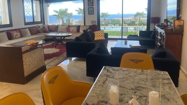 Un salon spacieux comprenant un ensemble de canapés, une table à manger et une vue sur l’océan.