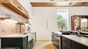 Une cuisine moderne avec des meubles en bois, un évier en acier inoxydable et une fenêtre donnant sur un paysage verdoyant.