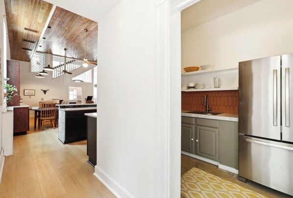 A modern kitchen with a stainless steel refrigerator, a built-in oven, and a large island with seating.