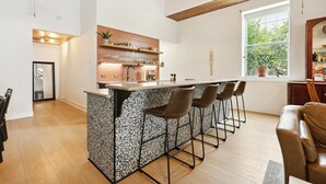 Une cuisine moderne dotée d’un îlot central, de tabourets de bar et d’une fenêtre offrant une belle vue.