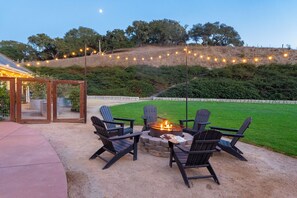 Un patio con mobiliario exterior y una chimenea.