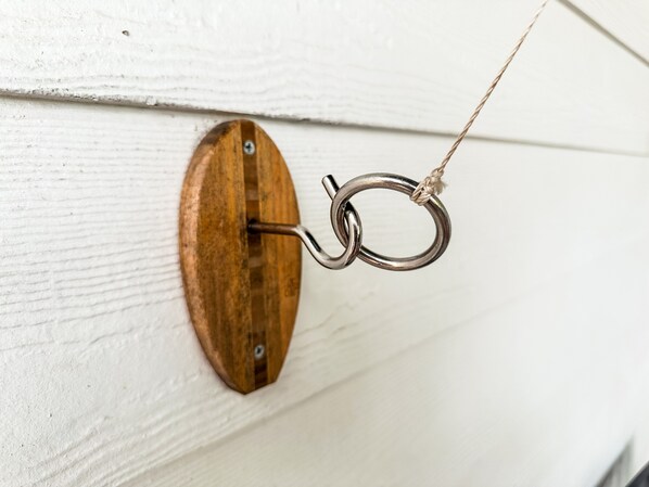 A wooden door with a metal hook attached to it.