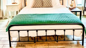 A bedroom with a bed, a nightstand, a lamp, and a window with curtains. - 4BR Sleeps 12 - Hottub Firepit - 1 Mile to Lake & River! (Canyon Lake)