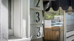 Un bâtiment à l’extérieur blanc, avec une fenêtre sur laquelle on peut voir les chiffres 2, 3 et 4.