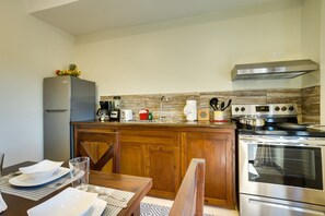 A kitchen with wooden cabinets, a stainless steel refrigerator, a stove, and a sink.