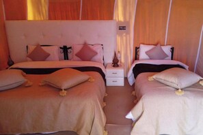 Ein Doppelzimmer mit zwei Betten, jeweils mit Kopfteil, Nachttischen und Dekokissen.