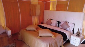 Un dormitorio con cama, mesita de noche y lámpara.
