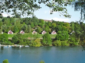 Een uitzicht op een meer met een rij huizen, een steiger en boten.