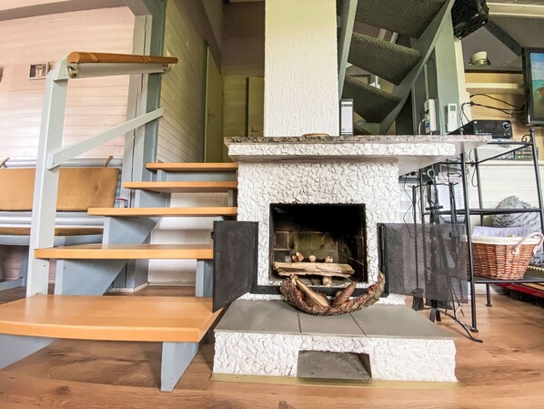 A staircase with wooden steps and a stone fireplace with a firebox.