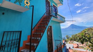 Ein türkisfarbenes Gebäude mit Treppe und Bergblick.