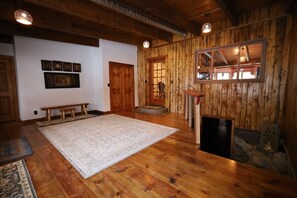 A spacious room with wooden floors, a large rug, wooden benches, and a fireplace. - Expect! WOW! Jacuzzi, Game Room, Fire Pit, Waterbed, Massage Chair, Remodel 2024 (Glenwood Springs)
