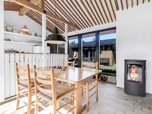 Eine moderne Küche mit Holzmöbeln, einem Esstisch und einem großen Fenster.