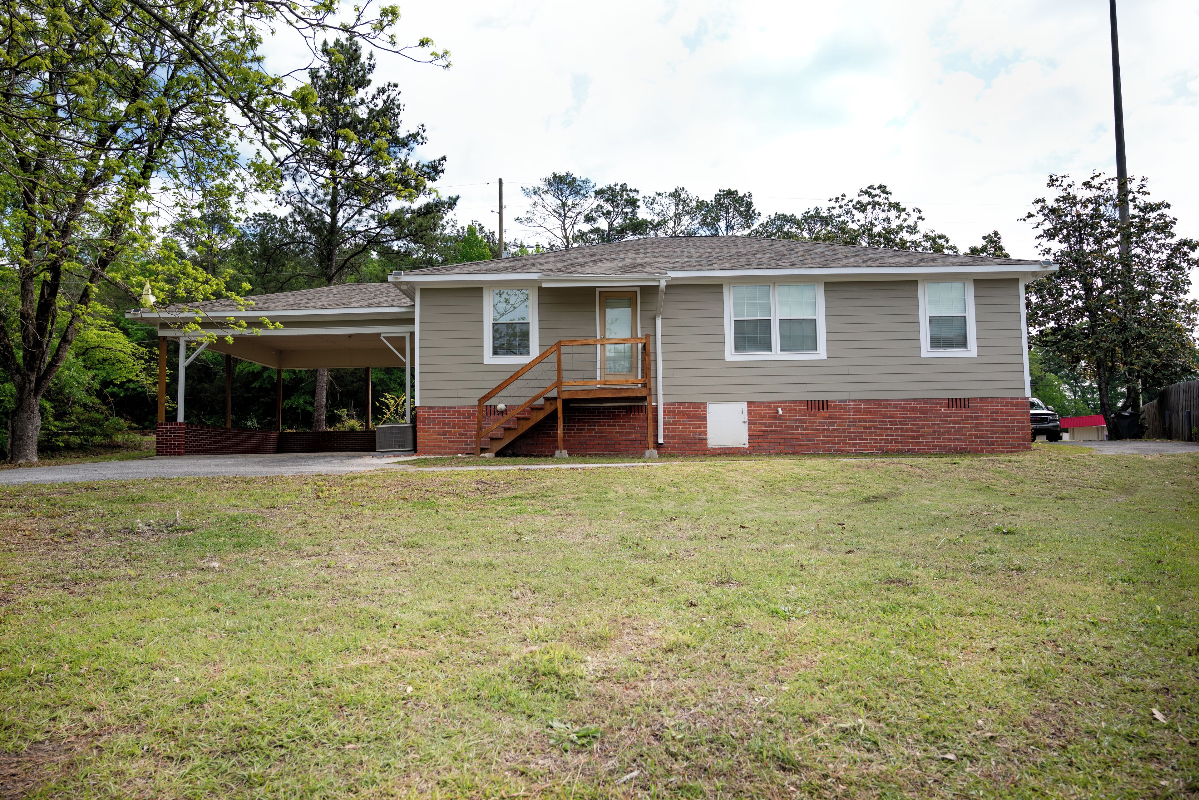 A single-story house with a covered porch and a small staircase leading to the front door.