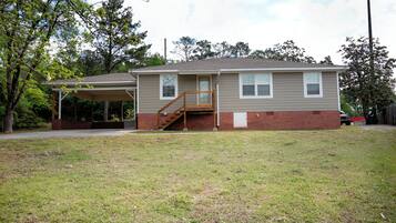 A single-story house with a covered porch and a small staircase leading to the front door.