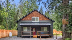 A cabin with a front porch, a red door, and large windows. - Perch - Spacious Modern Cabin w/ Hot Tub, BBQ & Cali- King-Sized Bed | Pet-Friendly (Ashford)