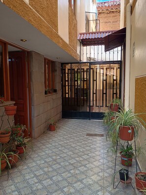 Stroll through this serene courtyard, surrounded by lush greenery and a geometric tile pattern.