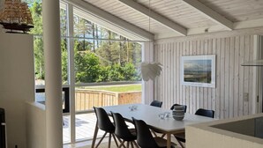 A dining area with a table, chairs, and a view of the outdoors. - "Ingwin" -  from the sea by Interhome (Hals)