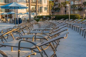 Filea di sdraio con struttura in metallo, prive di imbottitura, disposte su una terrazza piastrellata.