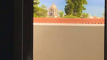 A view through a window with a building and trees in the background.