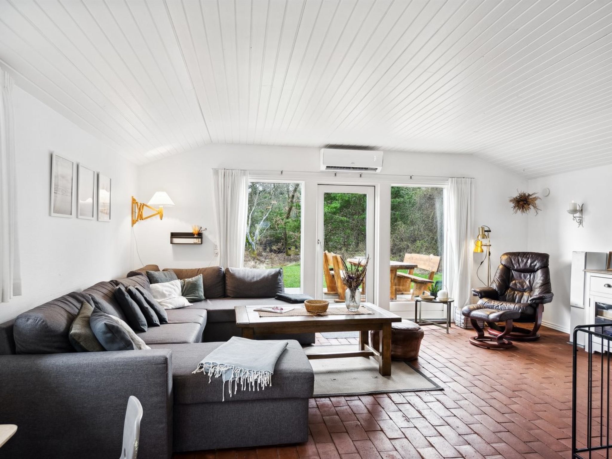A modern living room with a sectional sofa, a wooden coffee table, and a leather armchair.