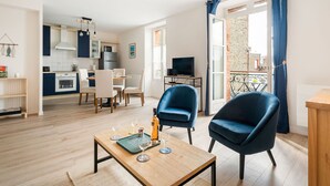 Un appartement moderne comprenant un coin repas, une cuisine et un balcon agrémenté de rideaux bleus.