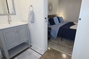 A bathroom with a white sink, a towel rack, and a mirror.
