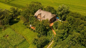Eine Vogelperspektive auf ein Haus, umgeben von üppigen grünen Feldern und Bäumen.