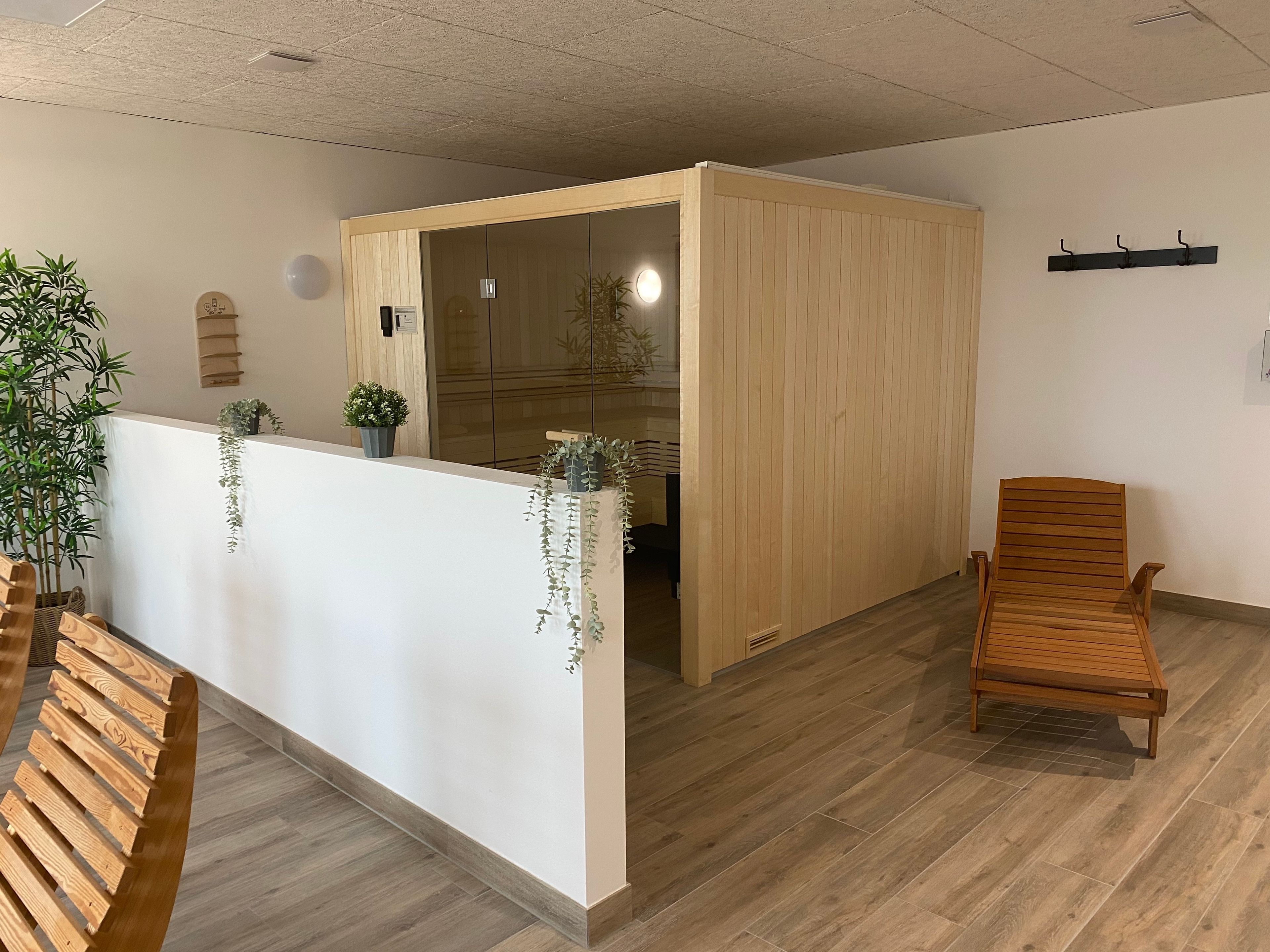 Een receptiegedeelte met een houten receptiebalie, een houten bank en een schuifdeur naar een kamer.