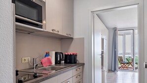 A kitchen with a microwave, coffee maker, and a sink. - Studio 'With Great Sea View of Island' with Sea View, Private Garden and Wi-Fi (Cuxhaven)