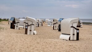 Beach chairs lined up on a sandy beach with the ocean in the background. - Studio 'With Great Sea View of Island' with Sea View, Private Garden and Wi-Fi (Cuxhaven)