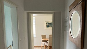A hallway with a dining area in the background, a wooden floor, and a mirror on the wall. - Apartment 'Ehemaliges Gutsverwalterhaus' with Shared Terrace, Shared Garden and Wi-Fi (Woldegk OT Mildenitz)