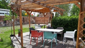 A wooden deck with a pergola, outdoor furniture, and potted plants. - Apartment 'Ehemaliges Gutsverwalterhaus' with Shared Terrace, Shared Garden and Wi-Fi (Woldegk OT Mildenitz)