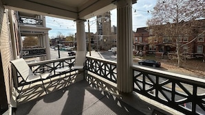 A covered outdoor seating area with a view of a street and buildings.