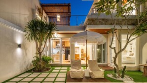 A modern outdoor patio with a pool, lounge chairs, and a dining area. - 2BR Private Pool Villa Dove By Orivista (Mengwi)